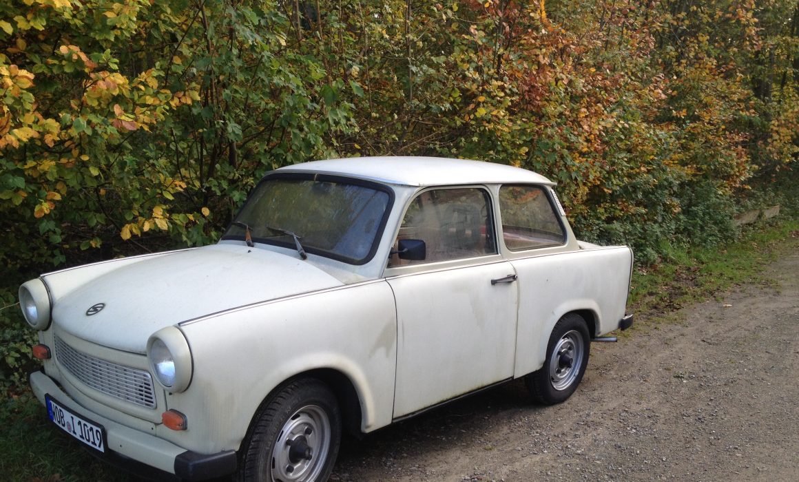 Trabant parked next to a hedge