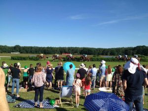 People watching as horses race past